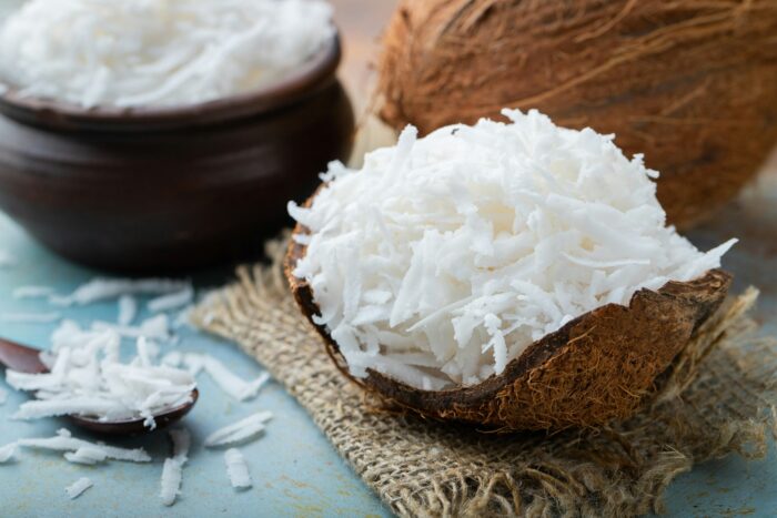 Coconut flakes in a shell on a blue background